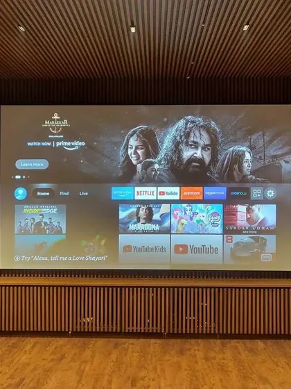 We specialize in seamlessly integrating large-format screens into your home's design. This installation features a projector screen perfectly fitted within a custom wood-paneled wall for a clean and modern aesthetic.