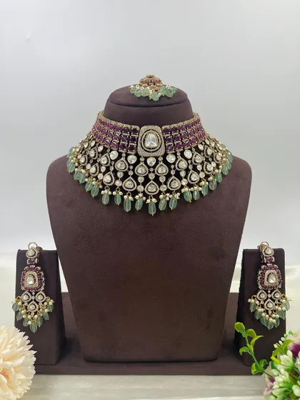 An exceptionally crafted bridal necklace set combining ruby-colored stones with mint-green bead drops. This piece demonstrates our ability to create complex, multi-colored designs with premium Moissanite stones for a rich, designer appeal.