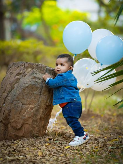 Pushing up against a rock, this little explorer is on the move. Outdoor shoots are perfect for capturing these moments of discovery.