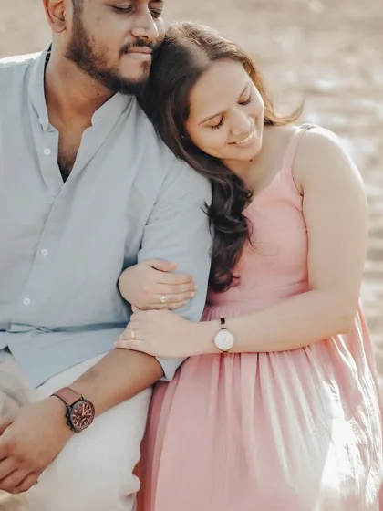 A serene and intimate portrait. This pose feels natural and relaxed, capturing a quiet moment of togetherness during their beach photoshoot.