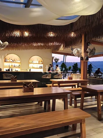The bar area at ISSA Goa at dusk, where the warm lighting and natural materials create an inviting atmosphere. The design blends local Goan charm with modern European and Mediterranean styles for a unique hospitality experience.
