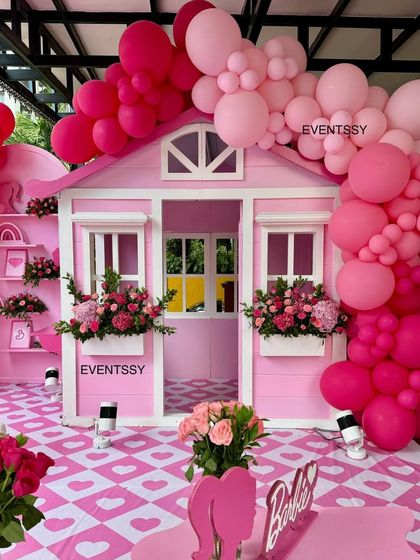 The custom-built pink playhouse, adorned with flower boxes and a massive balloon garland.