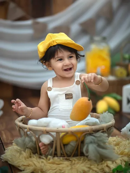 Got it! A playful moment as he proudly shows off his mango. We encourage interaction with props to bring out your child's natural curiosity.