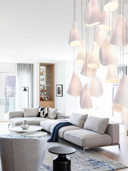 A Bocci 21 chandelier in a contemporary living room, its organic forms softening the clean lines of the modern furniture.