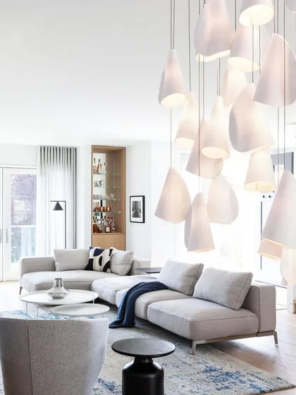 The Bocci 21 series adds a touch of organic sculpture to a bright, modern living room. The cluster of pendants provides both ambient light and a strong visual focal point.