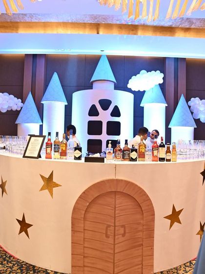 A whimsical castle-shaped bar for a fantasy-themed party. The design, complete with turrets and stars, turns a functional bar into a piece of fairytale decor.