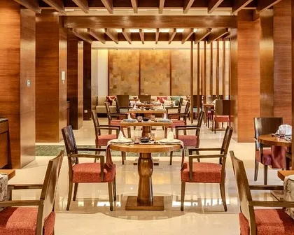 The main dining area of Tamari, characterized by warm wood tones and structured architectural details. The design creates a sophisticated and welcoming ambiance, reflecting the essence of Asian hospitality.