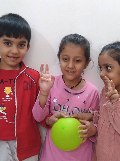 Three friends sharing a fun moment in class. The collaborative and social aspects of my art sessions help children build important communication skills.