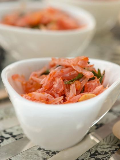 A light and refreshing pomelo salad, served in a stylish white bowl. This bite-sized delicacy is a perfect palate cleanser or a light start to a multi-course meal.