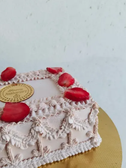 This is my vintage-style anniversary cake, decorated with intricate piping and fresh strawberries. It's a beautiful and elegant way to celebrate a special milestone.
