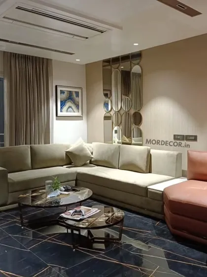 A complete living room designed and furnished by us. This space features a custom L-shaped sofa, a nested marble-top center table, and a unique leather armchair, all set against a dark marble floor for a modern, luxurious feel.