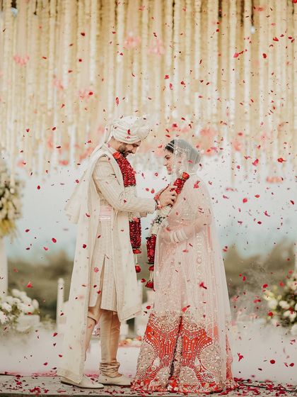 A magical moment as flower petals shower the couple. This image, filled with movement and color, perfectly captures the celebratory and blessed feeling of the wedding ceremony.