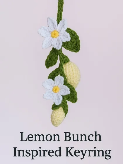 A lemon bunch inspired keyring, with multiple lemons and flowers hanging from a crocheted vine. It's a beautiful piece of fiber art.