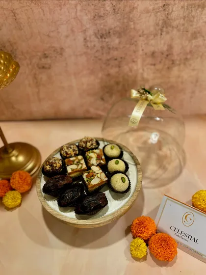Our 'Magnificent Sweet Cloche' is a beautiful keepsake gift, featuring a selection of our healthy mithai presented under a glass dome on a wooden base.