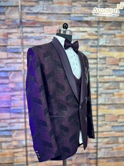 This side angle of the wine suit highlights the sleek silhouette and the contrast between the patterned jacket and satin lapels.
