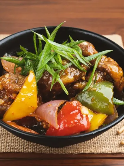 A bowl of chili mushroom with colorful bell peppers. This shot is styled for an online menu, focusing on clarity and appetite appeal.