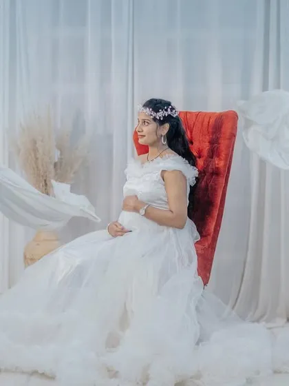 For a timeless and angelic look, I offer classic white gowns like this one. The delicate ruffles and flowing fabric create a pure and serene portrait, perfect for an indoor studio setting.