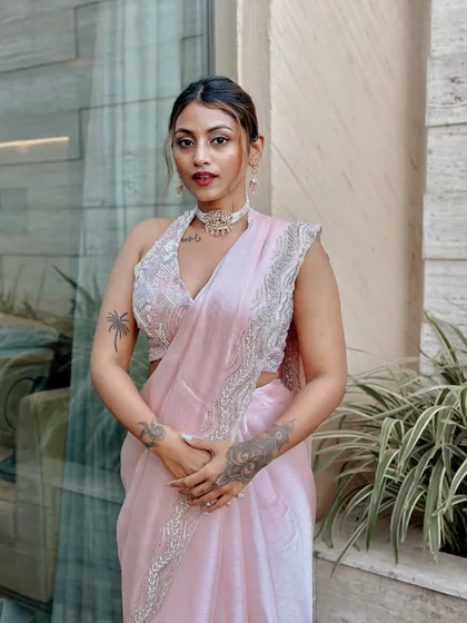 For me, Indian festive fashion is about blending tradition with a modern feel. This look features a delicate pink saree with an embellished halter-neck blouse, creating a style that's both elegant and contemporary.