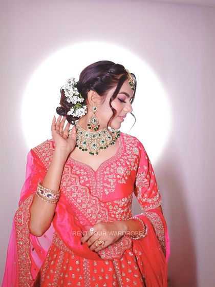 A beautiful shot focusing on the hairstyle and jewellery. The floral bun and emerald choker add a touch of modern elegance to this traditional look.