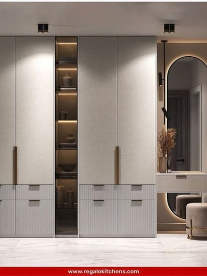 This wardrobe features a built-in dresser and an illuminated oval mirror. The textured door panels and slim handles add a layer of subtle, modern detail.