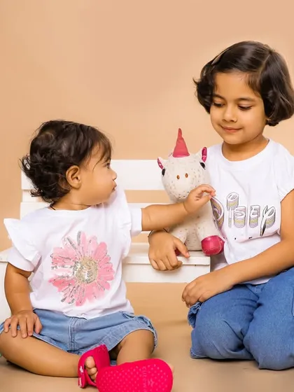 A sweet moment between two sisters as they play with a toy unicorn. Our studio is a great place for siblings to interact naturally while we capture their connection.