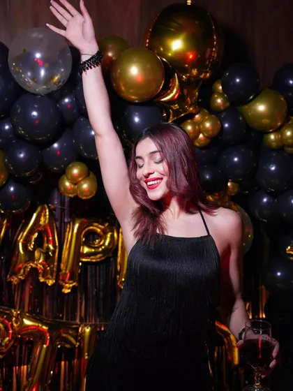 My goal is to create a vibe where everyone can relax and have a great time. This adult birthday party setup with a black and gold balloon wall and foil curtains provided a chic and celebratory backdrop for a night of fun.