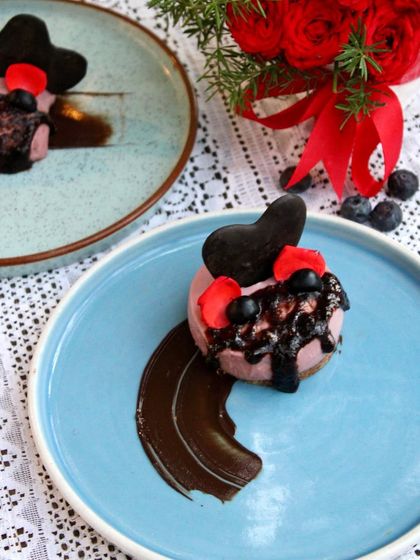 An overhead view of my Blueberry Cheesecake, showing the rich blueberry compote drizzle and the artistic chocolate smear on the plate. Every dessert I create is plated with care to be a feast for the eyes as well as the palate.