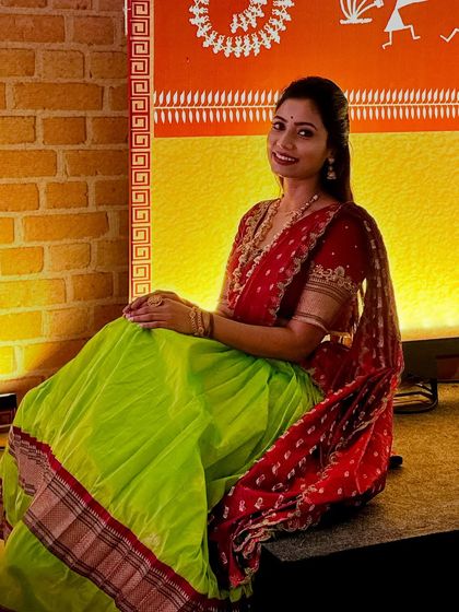 A lovely seated pose showing the comfort and grace of the langa voni. The rich colours and traditional border of the skirt stand out, making it a very photogenic outfit.