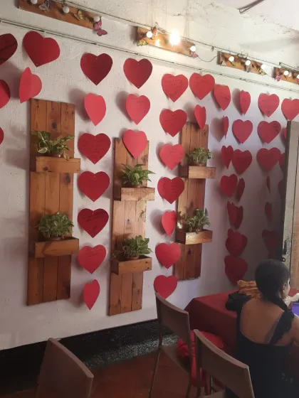 A guest enjoys the ambiance, surrounded by our wall of hearts and lush green plants.