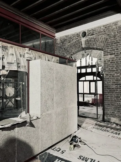 The juxtaposition of materials is a core part of our design language. A modern, textured panel is carefully positioned against the historic brick wall, a clear demonstration of our turnkey design and build process in action.