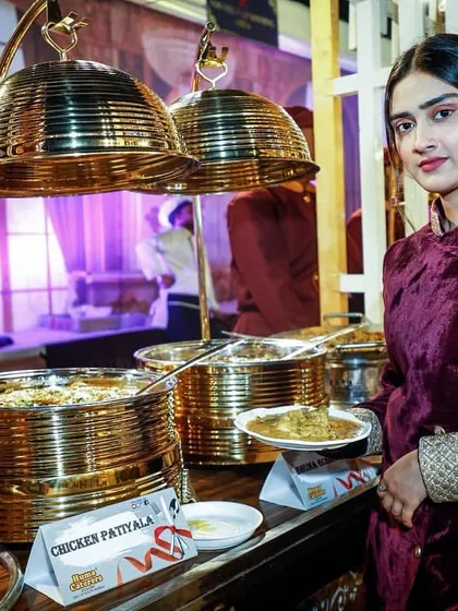 A staff member at the buffet, ready to serve guests with a smile. Our team is trained to be helpful and attentive at all times.