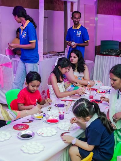 A full table of kids and parents enjoying a painting session together. My creative workshops are designed to be fun for the whole family.