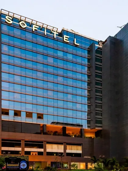 A ground-level perspective of the Sofitel, showcasing the grand entrance and podium levels that welcome guests into a world of sophisticated design and warm hospitality.