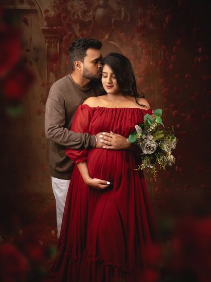 A gentle kiss on the forehead is a timeless expression of love and care. The addition of a bouquet adds a soft, romantic touch to this bold, red themed shoot.