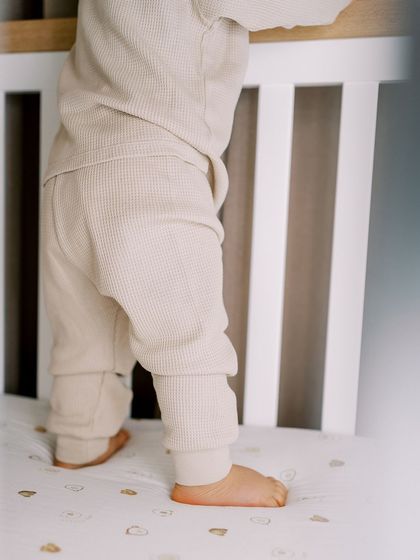 A close-up of a baby's feet as he stands in his crib. A simple, beautiful detail from a one-year-old's lifestyle session.