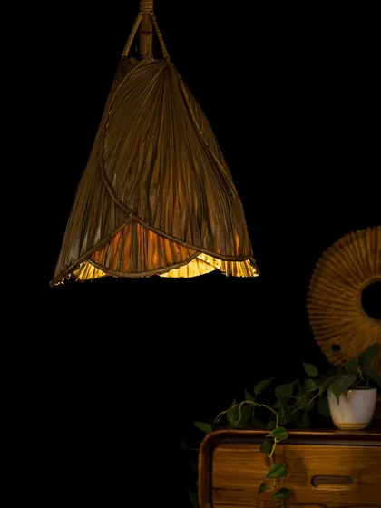 This unique pendant light is crafted from carefully arranged dried palm leaves, creating a delicate, almost floral shape. It provides a soft, downward glow, making it an elegant choice for adding a touch of nature-inspired design to any room.