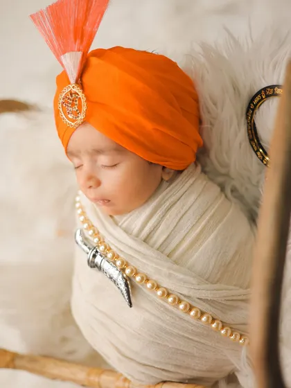I am honored to create culturally significant portraits. This newborn is styled with a traditional Sikh turban and kirpan, showcasing my ability to handle sensitive and meaningful themes with the utmost respect and care.
