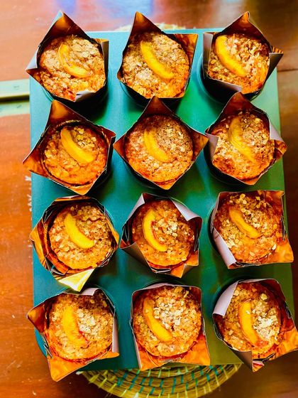 A tray full of spiced peach and carrot whole wheat muffins, ready for a teacher's birthday party.