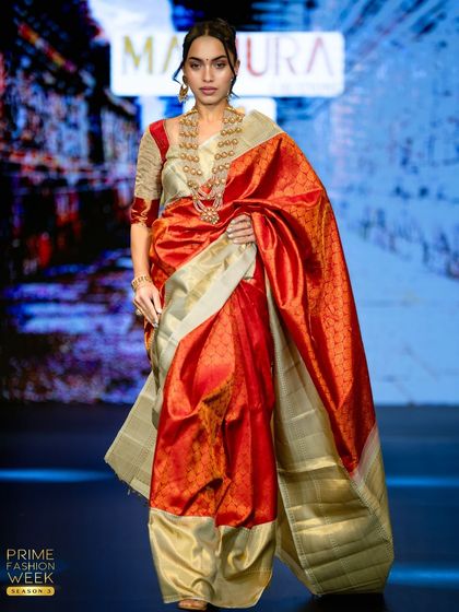 A final look at the red and off-white saree on the runway, a piece that combines tradition with high-fashion elegance.