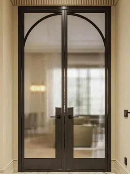 This image shows fluted glass in action on a set of beautiful arched doors, demonstrating how it can elevate an entryway.