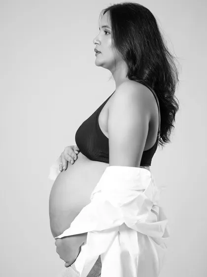 A profile shot in black and white beautifully emphasizes the silhouette of pregnancy. This artistic angle focuses on the curve of the baby bump in a simple and elegant way.