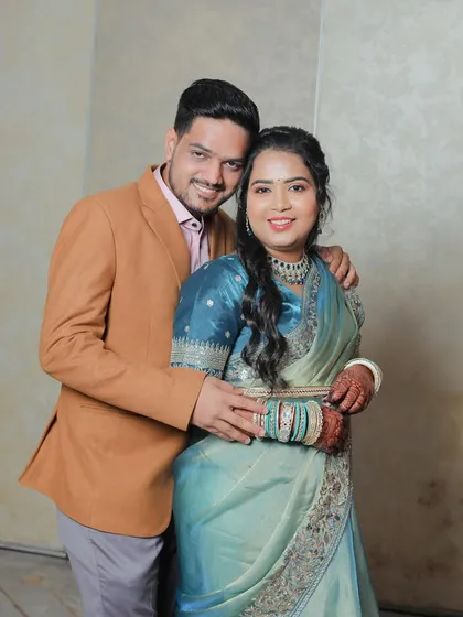 A warm and happy portrait of the couple after their engagement. The groom embraces the bride as they both smile for the camera, dressed in their elegant reception attire.