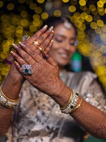 A close-up on the details. This shot highlights the bride's henna, her stunning emerald ring, and the kundan bangles from my rental collection.