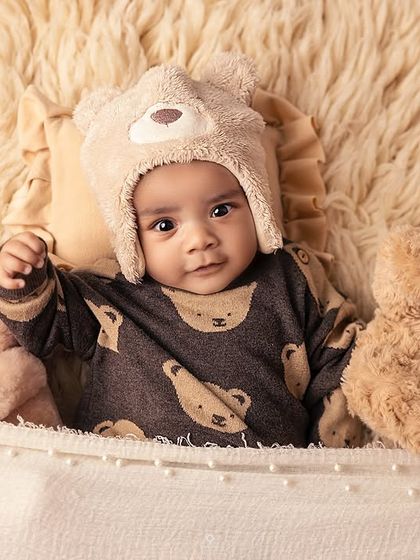 Peeking over the edge of the basket, this little teddy bear is all smiles. I use cozy textures and props to ensure babies are comfortable and happy during their session.