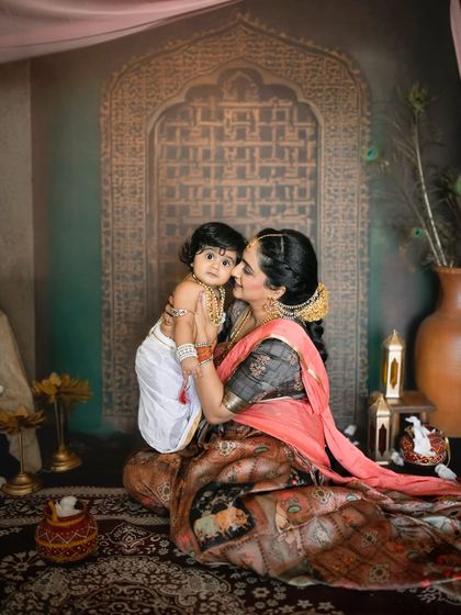An intimate embrace between mother and child. The lighting is carefully crafted to highlight their connection and the beauty of their traditional attire.