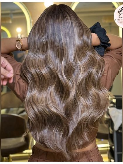 The back view showcases the incredible dimension and shine of this ash blonde balayage.