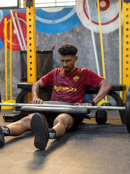 An athlete prepares for a heavy hip thrust, a key exercise for developing posterior chain power. This image showcases our high-performance equipment and the focused intensity of our strength sessions.