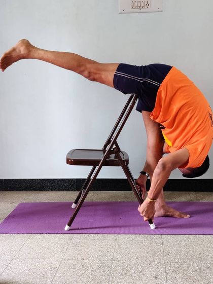 Eka Pada Uttanasana (Standing Split) with the standing leg supported by a chair. This allows for a greater focus on lifting the extended leg and squaring the hips.