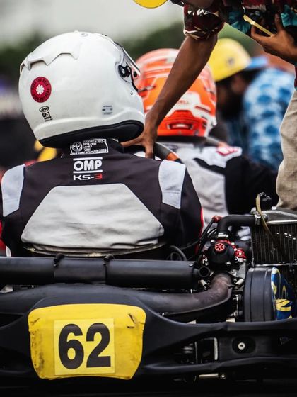 A driver receives a final pat on the back from a team member before heading out on track.