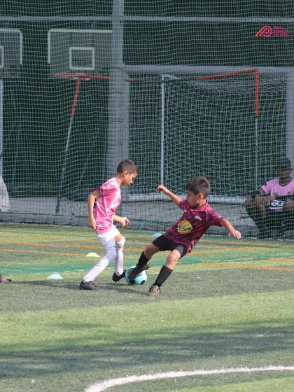 An Under-8 player engages in a tackle during a DPDL match, learning the art of defense.